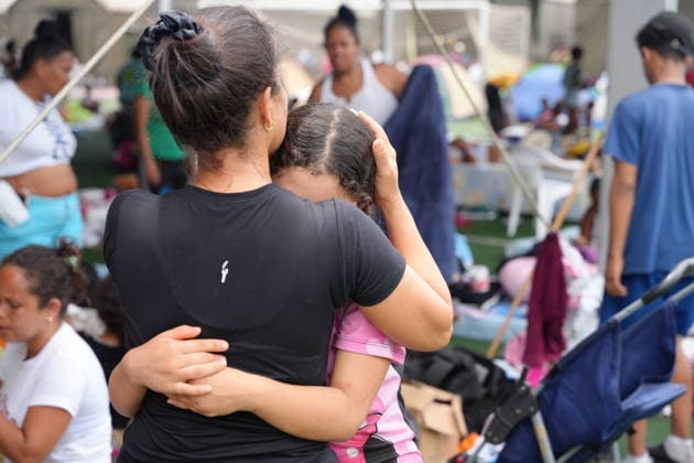 (260629) -- LA GUAIRA, June 29, 2026 -- A woman hugs a girl in a tent at a sports center in La Guaira, Venezuela, June 28, 2026. Venezuelan National Assembly President Jorge Rodriguez said Sunday that the death toll from two powerful earthquakes that uck Venezuela Wednesday has risen to 1,450. ( Xinhua) (SpotNews) VENEZUELA-LA GUAIRA-EARTHQUAKE-AFTERMATH STR 