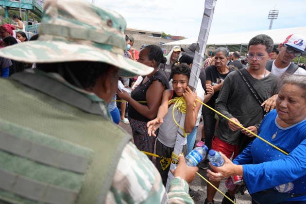 (260629) -- LA GUAIRA, June 29, 2026 -- People affected by earthquakes receive water at a sports center in La Guaira, Venezuela, June 28, 2026. Venezuelan National Assembly President Jorge Rodriguez said Sunday that the death toll from two powerful earthquakes that uck Venezuela Wednesday has risen to 1,450. ( Xinhua) (SpotNews) VENEZUELA-LA GUAIRA-EARTHQUAKE-AFTERMATH STR 