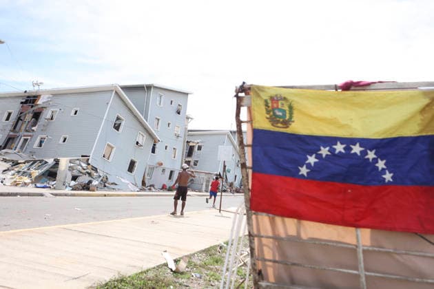 (260629) -- LA GUAIRA, June 29, 2026 -- A Venezuelan national flag is seen in an area affected by earthquakes in Playa Grande, La Guaira state, Venezuela, June 28, 2026. Venezuelan National Assembly President Jorge Rodriguez said Sunday that the death toll from two powerful earthquakes that uck Venezuela Wednesday has risen to 1,450. ( Xinhua) (SpotNews) VENEZUELA-LA GUAIRA-EARTHQUAKES-DEATH TOLL STR 