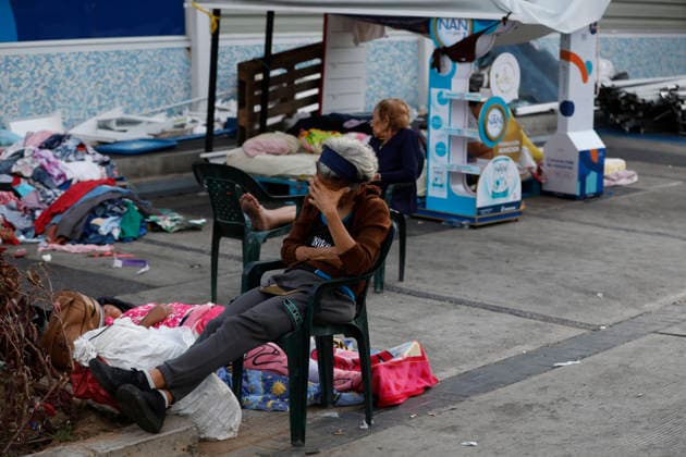 (260629) -- LA GUAIRA, June 29, 2026 -- People stay near a collapsed building in La Guaira, La Guaira state, Venezuela, June 28, 2026. Venezuelan National Assembly President Jorge Rodriguez said Sunday that the death toll from two powerful earthquakes that uck Venezuela Wednesday has risen to 1,450. ( Xinhua) (SpotNews) VENEZUELA-LA GUAIRA-EARTHQUAKES-DEATH TOLL STR 