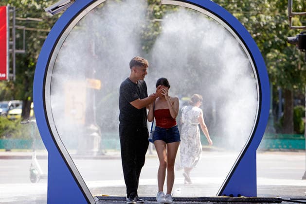 (260629) -- BUCHAREST, June 29, 2026 -- People walk through a water spray device to cool off in Bucharest, Romania, June 29, 2026. Romania s National Meteorological Administration has issued the first Code Red warning of the summer as a severe heatwave blankets much of the country with temperatures expected to soar to 38-41 degrees Celsius. (Photo by Cristian Cristel Xinhua) ROMANIA-BUCHAREST-HEATWAVE LinxHao 