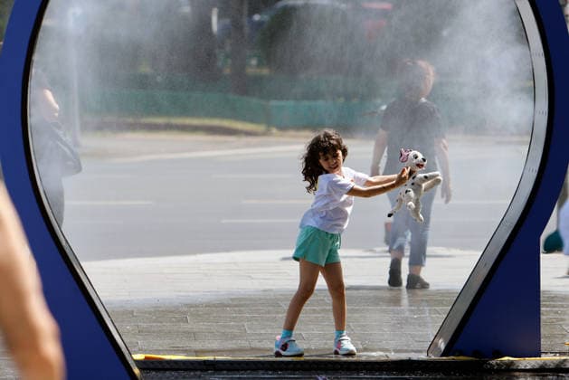 (260629) -- BUCHAREST, June 29, 2026 -- A girl enjoys a water spray device in Bucharest, Romania, June 29, 2026. Romania s National Meteorological Administration has issued the first Code Red warning of the summer as a severe heatwave blankets much of the country with temperatures expected to soar to 38-41 degrees Celsius. (Photo by Cristian Cristel Xinhua) ROMANIA-BUCHAREST-HEATWAVE LinxHao 