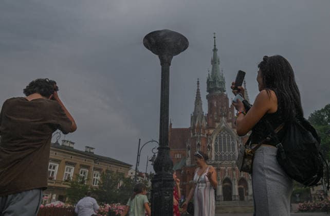 Historic Central European Heatwave Grips Krakow As Temperatures Hit 38C KRAKOW, POLAND - JUNE 29: Tourists use their smartphones to take pictures near a municipal water spray station under a hazy, overcast sky with building storm clouds in Podgorski Square, in Krakow, Poland, on June 29, 2026. This local snapshot captures conditions amid an unprecedented Central European heatwave, which just yesterday shattered Poland s 105-year-old national record with a blistering 40.5Â°C (104.9Â°F) in Slubice, as active orange alerts remain in place ahead of predicted severe regional storms set to collide with the lingering tropical air mass. Krakow Poland  Copyright: xArturxWidakx originalFilename: widak-historic260629_npOQG.jpg