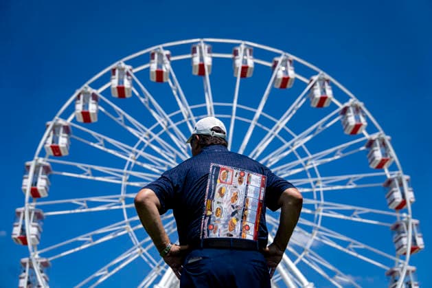 A visitor looks on toward the ferris wheel during the fifth day of the Great American State Fair on the National Mall on Monday, June 29, 2026. The Freedom 250-backed Great American State Fair celebrating the 250th anniversary of the United States runs through July 10th.  WAP20260629408 BONNIExCASH