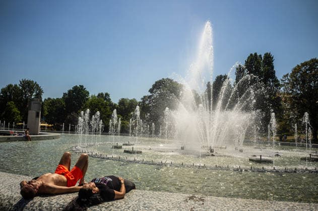 June 27, 2026, Warsaw, Mazovia, Poland: A couple relax in the sun next to a fountain. On the afternoon of the 28th of June, Varsovians cool and hydrate themselves around the city during a record-breaking heatwave. Due to the extreme heat, the authorities provided misting sprays and water tanks around the city. During the weekend, Warsaw experienced temperatures approaching 38Â°C as the unprecedented European heatwave swept across Poland, roughly 15Â°C above the late-June average. Tropical nights, nationwide heat alerts, and temperatures up to 40.5Â°C elsewhere in the country made this one of the most extreme heat events in modern Polish history. Warsaw Poland - ZUMAs197 20260627_aaa_s197_330 Copyright: xNeilxMiltonx
