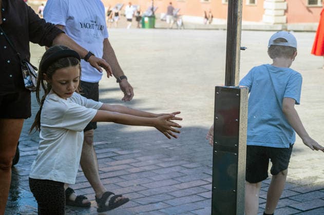 June 27, 2026, Warsaw, Mazovia, Poland: Young children enjoy the relief of a cooling misting station. On the afternoon of the 28th of June, Varsovians cool and hydrate themselves around the city during a record-breaking heatwave. Due to the extreme heat, the authorities provided misting sprays and water tanks around the city. During the weekend, Warsaw experienced temperatures approaching 38Â°C as the unprecedented European heatwave swept across Poland, roughly 15Â°C above the late-June average. Tropical nights, nationwide heat alerts, and temperatures up to 40.5Â°C elsewhere in the country made this one of the most extreme heat events in modern Polish history. Warsaw Poland - ZUMAs197 20260627_aaa_s197_331 Copyright: xNeilxMiltonx