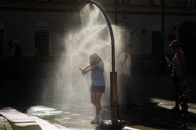 June 27, 2026, Warsaw, Mazovia, Poland: A young girl enjoys the relief of a cooling misting station. On the afternoon of the 28th of June, Varsovians cool and hydrate themselves around the city during a record-breaking heatwave. Due to the extreme heat, the authorities provided misting sprays and water tanks around the city. During the weekend, Warsaw experienced temperatures approaching 38Â°C as the unprecedented European heatwave swept across Poland, roughly 15Â°C above the late-June average. Tropical nights, nationwide heat alerts, and temperatures up to 40.5Â°C elsewhere in the country made this one of the most extreme heat events in modern Polish history. Warsaw Poland - ZUMAs197 20260627_aaa_s197_343 Copyright: xNeilxMiltonx