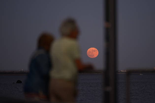 June 29, 2026, Lisbon, Portugal: People watch the moon rise over the Lisbon skyline. Strawberry Supermoon is a term derived from the traditions of the North American indigenous peoples, who called this moon by that name because it coincided with the wild strawberry harvest season. Lisbon Portugal - ZUMAs197 20260629_aaa_s197_070 Copyright: xJorgexCastellanosx