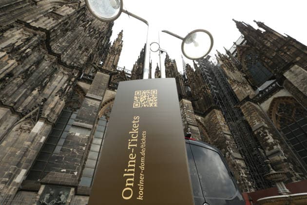An einem Stahlträger neben dem Kölner Dom wurde ein Schild angebracht, das auf die Website der römisch-katholischen Kirche hinweist, auf der es Online-Ticktes für Besichtigungstouren der Kathedrale zu erwerben gibt. Ab Mittwoch (1. Juli 2026) können Touristen den Innenraum des Domes nur noch nach Erwerb eines Tickets betreten. Köln Nordrhein-Westfalen *** A sign was attached to a steel beam next to Cologne Cathedral, pointing to the Roman Catholic Church’s website, where online tickets for guided tours of the cathedral can be purchased. Starting Wednesday, July 1, 2026, tourists will only be able to enter the cathedral’s interior after purchasing a ticket. Cologne, North Rhine-Westphalia
