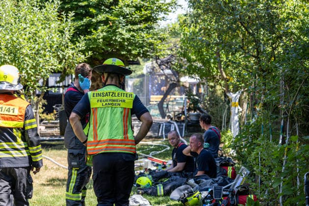Gartenhüttenbrand in Langen Feuerwehr verhindert Ausbreitung Am 30.06.2026 brannte gegen 13:00 Uhr eine Gartenhütte an der Frankfurter Straße in Langen. Das Feuer griff auf die umliegende Vegetation über und drohte, weitere Hütten zu erfassen. Drei Atemschutztrupps brachten den Brand unter Kontrolle; wegen asbesthaltiger Baumaterialien kam Schaummittel zum Einsatz. Die Löschwasserversorgung erfolgte durch zwei Löschfahrzeuge im Pendelverkehr, unterstützt von der Feuerwehr Dreieich. Knapp 35 Einsatzkräfte waren rund zwei Stunden vor Ort; im Anschluss folgten Hygienemaßnahmen an Einsatzstelle und Feuerwache Langen Hessen Deutschland *** Garden Shed Fire in Langen: Fire Department Prevents Spread On June 30, 2026, at around 1:00