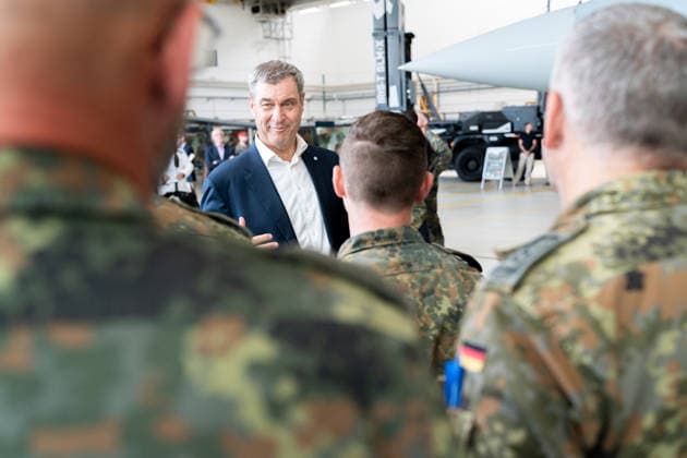 Kaufbeuren, Bavaria, Germany - June 30, 2026: Kaufbeuren Air Base, the Bundeswehr, and the German Air Force: The Future of the Arrow Weapon System for Germany (AWS-G), Air Defense, Military Base, and Pilot Project for Historic Preservation. Minister President Dr. Markus Söder (CSU) speaking with soldiers in Bundeswehr Flecktarn uniforms *** Fliegerhorst Kaufbeuren, Bundeswehr und Luftwaffe: Zukunft des Arrow Weapon System for Germany (AWS-G), Luftverteidigung, Militärstandort und Pilotvorhaben Denkmalschutz. Ministerpräsident Dr. Markus Söder (CSU) im Gespräch mit Soldaten in Flecktarn Uniform der Bundeswehr