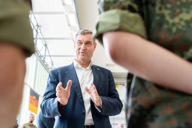 Kaufbeuren, Bavaria, Germany - June 30, 2026: Kaufbeuren Air Base, the Bundeswehr, and the German Air Force: The Future of the Arrow Weapon System for Germany (AWS-G), Air Defense, Military Base, and Pilot Project for Historic Preservation. Minister President Dr. Markus Söder (CSU) speaking with soldiers in Bundeswehr Flecktarn uniforms *** Fliegerhorst Kaufbeuren, Bundeswehr und Luftwaffe: Zukunft des Arrow Weapon System for Germany (AWS-G), Luftverteidigung, Militärstandort und Pilotvorhaben Denkmalschutz. Ministerpräsident Dr. Markus Söder (CSU) im Gespräch mit Soldaten in Flecktarn Uniform der Bundeswehr