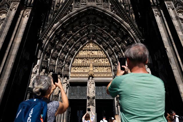 Touristen schießen Handybilder am Eingang des Kölner Dom. Ab dem 1. Juli müssen Besucherinnen und Besucher zwölf Euro Eintritt pro Person berappen. Freien Eintritt nur noch u.a. Gottesdienstbesucher und Betende. (Themenbild, Symbolbild) Köln, 29.06.2026 NRW Deutschland *** Tourists take photos with their cell phones at the entrance to Cologne Cathedral. Starting July 1, visitors will have to pay a 12-euro admission fee per person. Free admission will be limited to, among others, churchgoers and those attending services. Thematic image, symbolic image. Cologne, June 29, 2026. North Rhine-Westphalia, Germany Copyright: xChristophxHardtx
