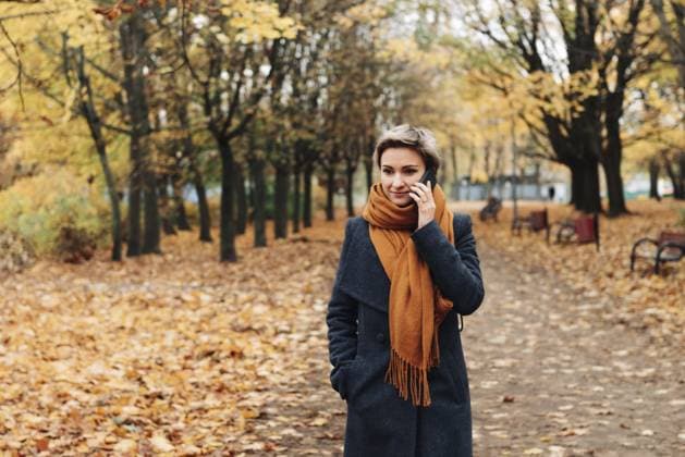 Kurzhaarige blonde Frau kommuniziert am Telefon und geht in Mantel und Schal im Herbstpark spazieren Short-haired blonde woman communicates on the phone walking in the autumn park in a coat and scarf Copyright: imageBROKER TatsianaxKalasouskay ibxmdz17887735.jpg ,model released, Symbolfoto ,property released