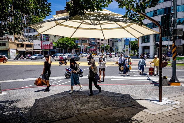 July 1, 2026, Kaohsiung City, Kaohsiung City, Taiwan: Commuters wait at a city intersection under a manual public sunshade, newly trialed by the Kaohsiung Mass Rapid Transit Bureau to counter severe summer heatwave on July 1, 2026 Kaohsiung City Taiwan - ZUMAh198 20260701_zip_h198_003 Copyright: xCheng-ChiaxHuangx