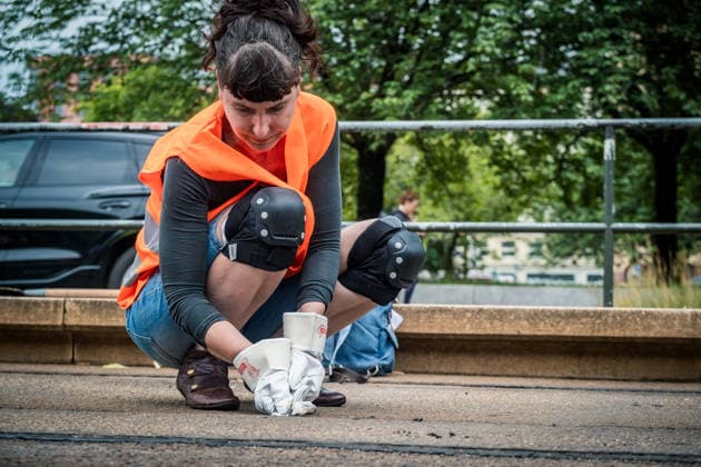 Leipziger Bürgerinnen und Bürger befreien am Johannisplatz gemeinsam mit den Leipziger Verkehrsbetrieben (LVB) die Straßenbahngleise von geschmolzenem Bitumen. Nachdem bereits am Vortag rund 100 Freiwillige einem Aufruf der LVB gefolgt waren, wurden die Reinigungsarbeiten am zweiten Tag am Johannisplatz fortgesetzt. Hintergrund sind die Schäden durch die extremen Temperaturen des vergangenen Hitzewochenendes. Aufnahme vom Datum . Reinigung Leipzig *** Residents of Leipzig are working together with the Leipzig Public Transportation Authority (LVB) to clear melted asphalt from the tram tracks at Johannisplatz. After about 100 volunteers had already responded to a call for help from the LVB the previous day, cleanup efforts continued on t