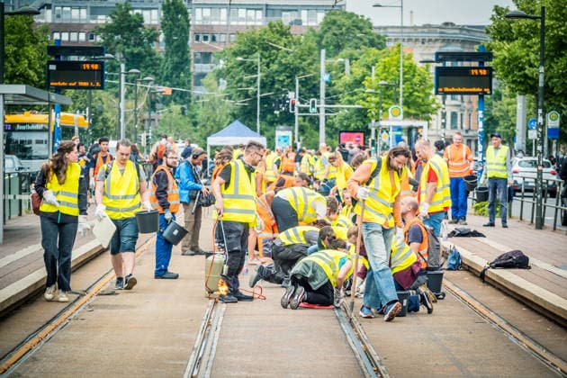 Leipziger Bürgerinnen und Bürger befreien am Johannisplatz gemeinsam mit den Leipziger Verkehrsbetrieben (LVB) die Straßenbahngleise von geschmolzenem Bitumen. Nachdem bereits am Vortag rund 100 Freiwillige einem Aufruf der LVB gefolgt waren, wurden die Reinigungsarbeiten am zweiten Tag am Johannisplatz fortgesetzt. Hintergrund sind die Schäden durch die extremen Temperaturen des vergangenen Hitzewochenendes. Aufnahme vom Datum . Reinigung Leipzig *** Residents of Leipzig are working together with the Leipzig Public Transportation Authority (LVB) to clear melted asphalt from the tram tracks at Johannisplatz. After about 100 volunteers had already responded to a call for help from the LVB the previous day, cleanup efforts continued on t