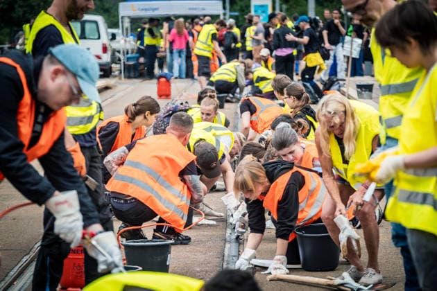 Leipziger Bürgerinnen und Bürger befreien am Johannisplatz gemeinsam mit den Leipziger Verkehrsbetrieben (LVB) die Straßenbahngleise von geschmolzenem Bitumen. Nachdem bereits am Vortag rund 100 Freiwillige einem Aufruf der LVB gefolgt waren, wurden die Reinigungsarbeiten am zweiten Tag am Johannisplatz fortgesetzt. Hintergrund sind die Schäden durch die extremen Temperaturen des vergangenen Hitzewochenendes. Aufnahme vom Datum . Reinigung Leipzig *** Residents of Leipzig are working together with the Leipzig Public Transportation Authority (LVB) to clear melted asphalt from the tram tracks at Johannisplatz. After about 100 volunteers had already responded to a call for help from the LVB the previous day, cleanup efforts continued on t