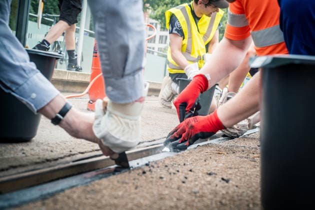 Leipziger Bürgerinnen und Bürger befreien am Johannisplatz gemeinsam mit den Leipziger Verkehrsbetrieben (LVB) die Straßenbahngleise von geschmolzenem Bitumen. Nachdem bereits am Vortag rund 100 Freiwillige einem Aufruf der LVB gefolgt waren, wurden die Reinigungsarbeiten am zweiten Tag am Johannisplatz fortgesetzt. Hintergrund sind die Schäden durch die extremen Temperaturen des vergangenen Hitzewochenendes. Aufnahme vom Datum . Reinigung Leipzig *** Residents of Leipzig are working together with the Leipzig Public Transportation Authority (LVB) to clear melted asphalt from the tram tracks at Johannisplatz. After about 100 volunteers had already responded to a call for help from the LVB the previous day, cleanup efforts continued on t