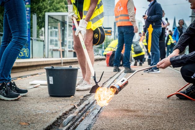 Leipziger Bürgerinnen und Bürger befreien am Johannisplatz gemeinsam mit den Leipziger Verkehrsbetrieben (LVB) die Straßenbahngleise von geschmolzenem Bitumen. Nachdem bereits am Vortag rund 100 Freiwillige einem Aufruf der LVB gefolgt waren, wurden die Reinigungsarbeiten am zweiten Tag am Johannisplatz fortgesetzt. Hintergrund sind die Schäden durch die extremen Temperaturen des vergangenen Hitzewochenendes. Aufnahme vom Datum . Reinigung Leipzig *** Residents of Leipzig, together with the Leipzig Public Transportation Authority (LVB), are clearing melted asphalt from the tram tracks at Johannisplatz. After about 100 volunteers had already responded to a call for help from the LVB the previous day, cleanup efforts continued on the sec