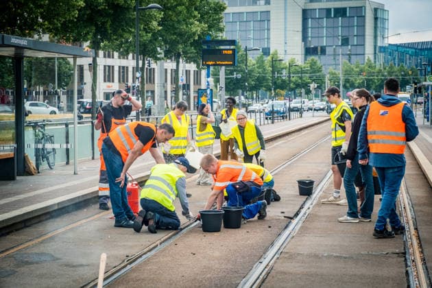Leipziger Bürgerinnen und Bürger befreien am Johannisplatz gemeinsam mit den Leipziger Verkehrsbetrieben (LVB) die Straßenbahngleise von geschmolzenem Bitumen. Nachdem bereits am Vortag rund 100 Freiwillige einem Aufruf der LVB gefolgt waren, wurden die Reinigungsarbeiten am zweiten Tag am Johannisplatz fortgesetzt. Hintergrund sind die Schäden durch die extremen Temperaturen des vergangenen Hitzewochenendes. Aufnahme vom Datum . Reinigung Leipzig *** Residents of Leipzig, together with the Leipzig Public Transportation Authority (LVB), are clearing melted asphalt from the tram tracks at Johannisplatz. After about 100 volunteers had already responded to a call for help from the LVB the previous day, cleanup efforts continued on the sec