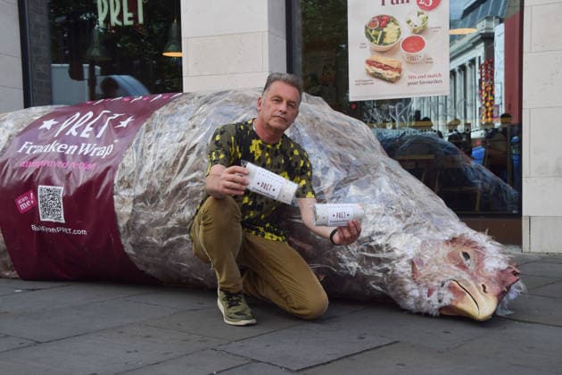 July 1, 2026, Ascot, England, United Kingdom: Naturalist and TV presenter CHRIS PACKHAM holds mock wraps containing information leaflets next to a giant animatronic wrapped chicken outside Pret in Waterloo during a protest urging the public to skip the fast food chain until they stop selling meat from Frankenchickens. Frankenchickens are chickens bred to grow artificially fast, and campaigners say they suffer far more than regular chickens. Ascot United Kingdom  - ZUMAv130 20260701_zip_v130_029 Copyright: xVukxValcicx