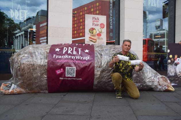July 1, 2026, Ascot, England, United Kingdom: Naturalist and TV presenter CHRIS PACKHAM holds mock wraps containing information leaflets next to a giant animatronic wrapped chicken outside Pret in Waterloo during a protest urging the public to skip the fast food chain until they stop selling meat from Frankenchickens. Frankenchickens are chickens bred to grow artificially fast, and campaigners say they suffer far more than regular chickens. Ascot United Kingdom - ZUMAv130 20260701_zip_v130_030 Copyright: xVukxValcicx