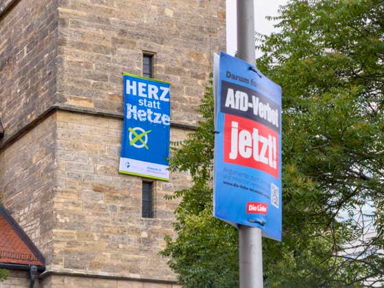 AfD-Verbot und Kirche 30062026 - Plakat AfD Verbot Jetzt, dahinter ein Banner Herz statt Hetze an der Kaufmannskirche in Erfurt. Die Evangelische Kirche in Mitteldeutschland waere auch bei einem Wahlsieg der AfD im Landtag von Sachsen-Anhalt sehr stark betroffen. Erfurt Anger Thueringen Deutschland *** AfD Ban and the Church 30062026 Poster: Ban the AfD Now, with a banner reading Love Instead of Hate behind it at the Kaufmannskirche in Erfurt. The Evangelical Church in Central Germany would also be severely affected if the AfD were to win an election in the state parliament of Saxony-Anhalt. Erfurt, Anger, Thuringia, Germany 300626_ppb-2
