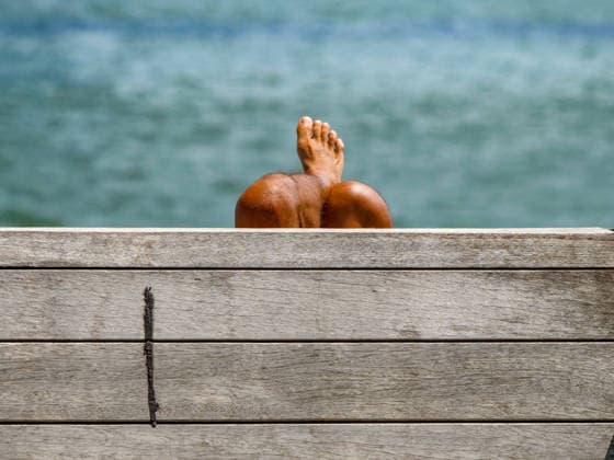 July 1, 2026, New York, New York, USA: Catching rays on Pier 17 NYC on the East River during a heatwave..Apparently the sunlover didn t mind the oppressive heat hovering.upwards of 100 degrees on the wooden deck of the structure.on the waterfront tanning. New York USA  - ZUMAh156 20260701_znp_h156_008 Copyright: xMiloxHessx