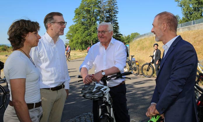 Bundespräsident Frank-Walter Steinmeier fährt in Begleitung des Lörracher Oberbürgermeisters Jörg Lutz (rechts) mit dem Fahrrad über die deutsch-schweizerische Grenze von Lörrach-Stetten nach Riehen. Am Grenzstein zur Schweiz trifft er die Gemeindepräsidentin von Riehen, Christine Kaufmann (links) sowie den basel-städtischen Regierungspräsidenten Conradin Cramer (2. v.l.). Bundespräsident Frank-Walter Steinmeier fährt in Begleitung des Lörracher Oberbürgermeisters Jörg Lutz (rechts) mit dem Fahrrad über die deutsch-schweizerische Grenze von Lörrach-Stetten nach Riehen. Am Grenzstein zur Schweiz trifft er die Gemeindepräsidentin von Riehen, Christine Kaufmann (links) sowie den basel-städtischen Regierungspräsidenten Conradin Cramer (2. v.l.)
