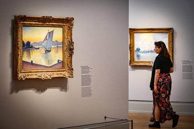 Symphonie der Farben. Paul Signac und der Neoimpressionismus ** NUR FÜR REDAKTIONELLE ZWECKE ** EDITORIAL USE ONLY **<p>Ausstellung Symphonie der Farben. Paul Signac und der Neoimpressionismus im Museum Barberini. Eine Frau geht während der Presse-Vorbesichtigung der Ausstellung Â«Symphonie der Farben. Paul Signac und der NeoimpressionismusÂ» an dem links hängenden Bild Der Hafen bei Sonnenuntergang (Saint-Tropez, 1892, Öl auf Leinwand) des Künstlers Paul Signac vorbei. Die Ausstellung ist bis zum 11.10.2026 zu sehen. Den höchsten Grad an Leuchtkraft und Harmonie zu erreichen diesem Ziel verschrieb sich Paul Signac, als er Mitte der 1880er-Jahre mit Georges Seurat eine neue Malweise in die Kunst einführte. Die Ausstellung Symp Copyright: MaurizioxGambarini doc86jl04h0ng9321isewm ,EDITORIAL USE ONLY