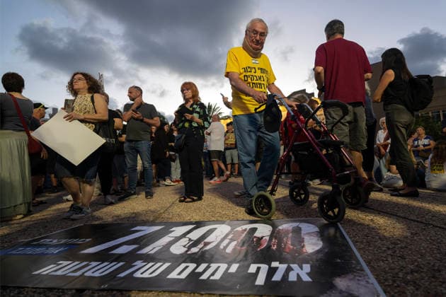 Anti-government rally in Tel Aviv - 02 Jul 2026 A protester stands next to a banner on the ground reading, 1,000 days of shiva. during an anti-government rally. A rally was held to mark 1,000 days since the October 7 massacre. Demonstrators protested against the Israeli government, accusing it of responsibility for the failures that led to the attack and calling for a state commission of inquiry, which they say the government opposes because its findings could implicate Prime Minister Benjamin Netanyahu. Tel Aviv Israel Copyright: xYaelxGuiskyxAbasx xSOPAxImagesx 9531s