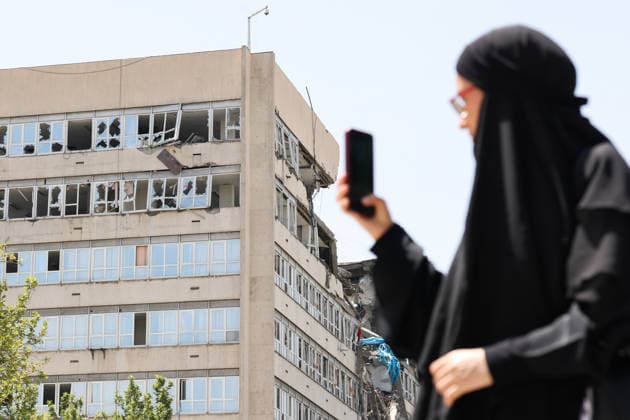 IRAN, TEHRAN - JULY 3, 2026: A woman walks past a damaged local government building on the eve of the state funeral of Supreme Leader Ali Khamenei (1939-2026) set to take place from July 4 to 9. Khamenei was killed in a joint US-Israeli airstrike on his residence on February 28. Valery Sharifulin TASS  94604621