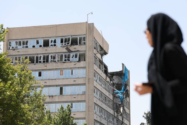 IRAN, TEHRAN - JULY 3, 2026: A woman walks past a damaged local government building on the eve of the state funeral of Supreme Leader Ali Khamenei (1939-2026) set to take place from July 4 to 9. Khamenei was killed in a joint US-Israeli airstrike on his residence on February 28 Tehran Iran  - ZUMAt113 20260703_zaa_t113_022 Copyright: xValeryxSharifulinx