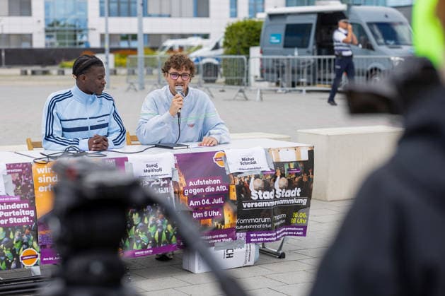 Pressekonferenz des Aktionsbuendnisses Widersetzen vor dem Messegelaende in Erfurt, wo der AfD-Parteitag am Wochenende stattfindet (Foto vom 03.07.2026; im Bild: Suraj Mailitafi (li.) und Michel Schmidt)). Das Aktionsbuendnis Widersetzen hat vor dem Bundesparteitag der AfD am 04.07.2026 in Erfurt die Blockade saemtlicher Zufahrtswege zum Veranstaltungsort angekuendigt. Ab 5.30 Uhr sollten die Anfahrtsstrassen zur Messe besetzt werden, teilte das Buendnis am Freitag mit. (Siehe epd-Meldung vom 03.07.2026) EDITORIAL USE ONLY *** Press conference held by the Widersetzen Action Alliance in front of the Erfurt exhibition grounds, where the AfD party convention is taking place this weekend. Photo from July 3, 2026, featuring Suraj Mailitafi Copyright: epd-bild Paul-PhilippxBraun 03072026_ppb-09