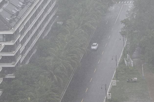 (260703) -- QIONGHAI, July 3, 2026 -- A vehicle travels in a street amid wind and rain in Qionghai, south China s Hainan Province, July 3, 2026. Typhoon Maysak, the 10th typhoon of the year, made landfall on the coast of south China s Hainan Province on Friday evening, suspending train, ferry and flight services and closing schools in some areas. The tropical storm came ashore at around 6:20 p.m. in Yelin Township of Lingshui Li Autonomous County, according to the Hainan provincial meteorological bureau. At landfall, it packed maximum winds of 23 meters per second near its center. The typhoon is forecast to move northwest, passing through Baoting, Wuzhishan, Baisha and Danzhou before entering the Beibu Gulf, the meteorological author 