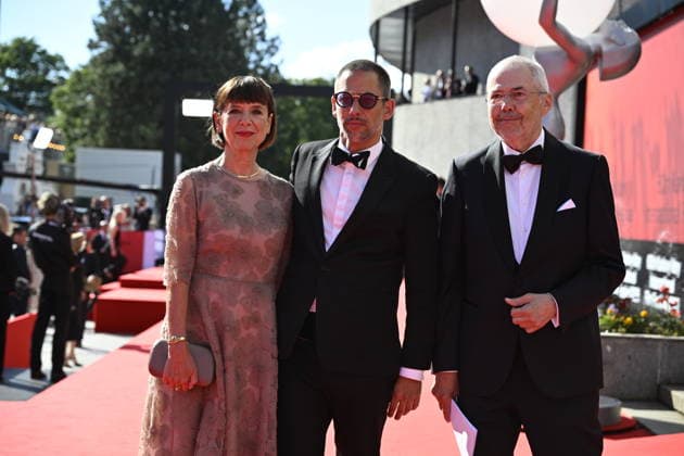 From left: archaeologist Andrea Bartoskova, actor Jan Janek Bartoska and moderator Marek Eben arrive at the opening of the 60th Karlovy Vary International Film Festival, on June 3, 2026, in Karlovy Vary, Czech Republic. (CTKxPhoto KaterinaxSulova) CTKPhotoP2026070306559  CTKPhotoP2026070306559