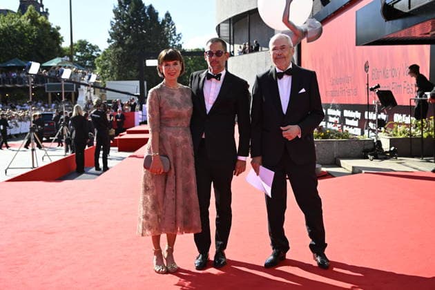 From left: archaeologist Andrea Bartoskova, actor Jan Janek Bartoska and moderator Marek Eben arrive at the opening of the 60th Karlovy Vary International Film Festival, on June 3, 2026, in Karlovy Vary, Czech Republic. (CTKxPhoto KaterinaxSulova) CTKPhotoP2026070306572  CTKPhotoP2026070306572