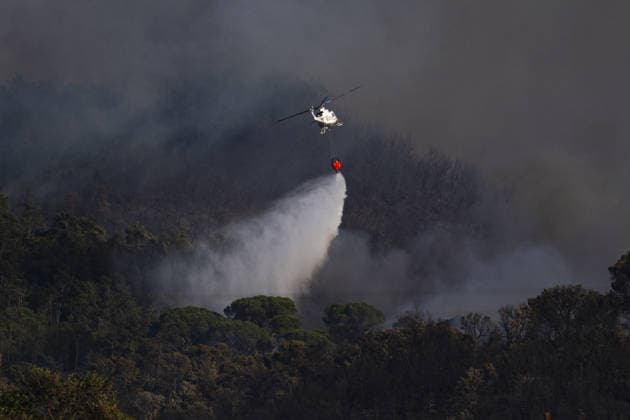 Spain battles major Costa Brava wildfire after 1,800 hectares burn LA BISBAL D’EMPORDA, SPAIN - JULY 03: A helicopter carries water to contain flames as a wildfire tears through the ecologically sensitive Les Gavarres mountain range in the Baix Emporda district of Catalonia, Spain, on July 3, 2026. A wildfire that broke out on Friday in the Baix Emporda district on Spain s Costa Brava has forced tens of thousands of people to remain indoors and has burned around 1,800 hectares, according to preliminary figures from regional authorities, as firefighters continue efforts to bring the blaze under control. Fanned by strong tramontana winds, the fire is affecting mainly the Les Gavarres mountain range, an area of high ecological value. Catalonia  Copyright: x2026xAnadoluxLorenaxSopenaxLopezx