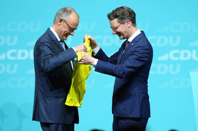 Landesparteitag der CDU NRW in Duesseldorf Hendrik Wuest, Ministerpraesident des Landes Nordrhein-Westfalen ueberreicht Bundeskanzler Friedrich Merz symbolisch das Gelbe Trikot des Fuehrenden in Anlehnung an die Tour de France beim Landesparteitag der CDU Nordrhein-Westfalen im Maritim Hotel, Duesseldorf, 04.07.2026 Duesseldorf NRW Deutschland *** CDU North Rhine-Westphalia State Party Convention in Düsseldorf: Hendrik Wuest, Minister-President of North Rhine-Westphalia, symbolically presents Federal Chancellor Friedrich Merz with the yellow leader’s jersey—modeled after the Tour de France—at the CDU North Rhine-Westphalia State Party Convention at the Maritim Hotel, Düsseldorf, July 4, 2026, Düsseldorf, North Rhine-Westphalia, Germany