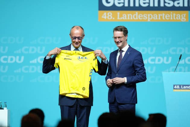 Landesparteitag der CDU NRW in Duesseldorf Bundeskanzler Friedrich Merz mit dem gelben Trikot des Fruehrenden in Anlehnung an die Tour de France ueberreicht durch Hendrik Wuest, Ministerpraesident des Landes Nordrhein-Westfalen beim Landesparteitag der CDU Nordrhein-Westfalen im Maritim Hotel, Duesseldorf, 04.07.2026 Duesseldorf NRW Deutschland *** CDU North Rhine-Westphalia State Party Convention in Düsseldorf: Federal Chancellor Friedrich Merz wearing the yellow leader’s jersey—a nod to the Tour de France—presented by Hendrik Wuest, Minister-President of North Rhine-Westphalia, at the CDU North Rhine-Westphalia State Party Convention at the Maritim Hotel, Düsseldorf, July 4, 2026, Düsseldorf, North Rhine-Westphalia, Germany