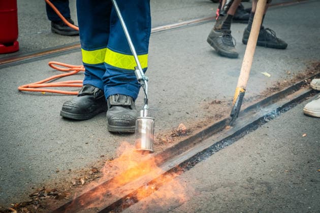 Freiwillige Helfer reinigen gemeinsam mit Mitarbeitenden der Leipziger Verkehrsbetriebe (LVB) Straßenbahngleise an der Leibnizstraße in Leipzig (Sachsen) von geschmolzenem Bitumen. Die Arbeiten sind Teil eines dritten Subbotniks zur Beseitigung der Hitzeschäden am Straßenbahnnetz. Aufnahme vom 4. Juli 2026. Hilfsaktion Leipzig *** Volunteers are working alongside employees of the Leipzig Public Transportation Authority (LVB) to clean melted bitumen off the tram tracks on Leibnizstraße in Leipzig, Saxony. The work is part of a third subbotnik aimed at repairing heat damage to the tram network. Photo taken on July 4, 2026. VolunteerLeipzig Relief Effort