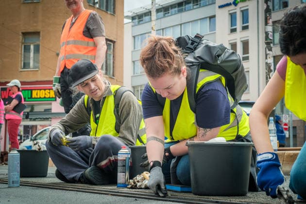 Freiwillige Helfer reinigen gemeinsam mit Mitarbeitenden der Leipziger Verkehrsbetriebe (LVB) Straßenbahngleise an der Leibnizstraße in Leipzig (Sachsen) von geschmolzenem Bitumen. Die Arbeiten sind Teil eines dritten Subbotniks zur Beseitigung der Hitzeschäden am Straßenbahnnetz. Aufnahme vom 4. Juli 2026. Hilfsaktion Leipzig *** Volunteers are working alongside employees of the Leipzig Public Transportation Authority (LVB) to clean melted bitumen from the tram tracks on Leibnizstraße in Leipzig, Saxony. The work is part of a third subbotnik aimed at repairing heat damage to the tram network. Photo taken on July 4, 2026. VolunteerLeipzig Relief Effort