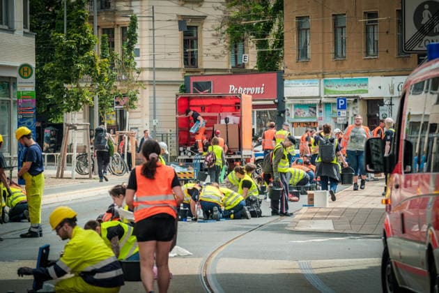 Freiwillige Helfer reinigen gemeinsam mit Mitarbeitenden der Leipziger Verkehrsbetriebe (LVB) Straßenbahngleise an der Leibnizstraße in Leipzig (Sachsen) von geschmolzenem Bitumen. Die Arbeiten sind Teil eines dritten Subbotniks zur Beseitigung der Hitzeschäden am Straßenbahnnetz. Aufnahme vom 4. Juli 2026. Hilfsaktion Leipzig *** Volunteers are working alongside employees of the Leipzig Public Transportation Authority (LVB) to clean melted bitumen off the tram tracks on Leibnizstraße in Leipzig, Saxony. The work is part of a third subbotnik aimed at repairing heat damage to the tram network. Photo taken on July 4, 2026. VolunteerLeipzig Relief Effort