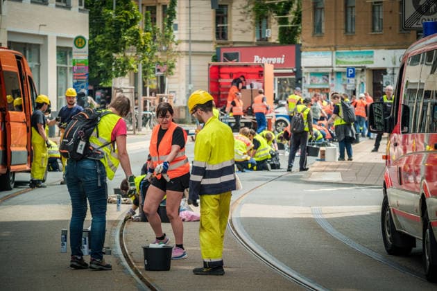 Freiwillige Helfer reinigen gemeinsam mit Mitarbeitenden der Leipziger Verkehrsbetriebe (LVB) Straßenbahngleise an der Leibnizstraße in Leipzig (Sachsen) von geschmolzenem Bitumen. Die Arbeiten sind Teil eines dritten Subbotniks zur Beseitigung der Hitzeschäden am Straßenbahnnetz. Aufnahme vom 4. Juli 2026. Hilfsaktion Leipzig *** Volunteers are working alongside employees of the Leipzig Public Transportation Authority (LVB) to clean melted bitumen from the tram tracks on Leibnizstraße in Leipzig, Saxony. The work is part of a third subbotnik aimed at repairing heat damage to the tram network. Photo taken on July 4, 2026. VolunteerLeipzig Relief Effort