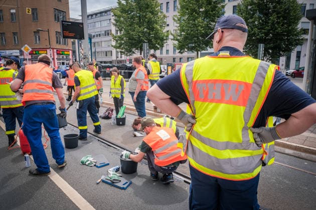 Freiwillige Helfer reinigen gemeinsam mit Mitarbeitenden der Leipziger Verkehrsbetriebe (LVB) Straßenbahngleise an der Leibnizstraße in Leipzig (Sachsen) von geschmolzenem Bitumen. Die Arbeiten sind Teil eines dritten Subbotniks zur Beseitigung der Hitzeschäden am Straßenbahnnetz. Aufnahme vom 4. Juli 2026. Hilfsaktion Leipzig *** Volunteers are working alongside employees of the Leipzig Public Transportation Authority (LVB) to clean melted bitumen from the tram tracks on Leibnizstraße in Leipzig, Saxony. The work is part of a third subbotnik aimed at repairing heat damage to the tram network. Photo taken on July 4, 2026. VolunteerLeipzig Relief Effort