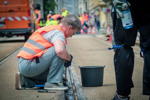Freiwillige Helfer reinigen gemeinsam mit Mitarbeitenden der Leipziger Verkehrsbetriebe (LVB) Straßenbahngleise an der Leibnizstraße in Leipzig (Sachsen) von geschmolzenem Bitumen. Die Arbeiten sind Teil eines dritten Subbotniks zur Beseitigung der Hitzeschäden am Straßenbahnnetz. Aufnahme vom 4. Juli 2026. Hilfsaktion Leipzig *** Volunteers are working alongside employees of the Leipzig Public Transportation Authority (LVB) to clean melted bitumen off the tram tracks on Leibnizstraße in Leipzig, Saxony. The work is part of a third subbotnik aimed at repairing heat damage to the tram network. Photo taken on July 4, 2026. VolunteerLeipzig Relief Effort