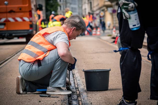 Freiwillige Helfer reinigen gemeinsam mit Mitarbeitenden der Leipziger Verkehrsbetriebe (LVB) Straßenbahngleise an der Leibnizstraße in Leipzig (Sachsen) von geschmolzenem Bitumen. Die Arbeiten sind Teil eines dritten Subbotniks zur Beseitigung der Hitzeschäden am Straßenbahnnetz. Aufnahme vom 4. Juli 2026. Hilfsaktion Leipzig *** Volunteers are working alongside employees of the Leipzig Public Transportation Authority (LVB) to clean melted bitumen off the tram tracks on Leibnizstraße in Leipzig, Saxony. The work is part of a third subbotnik aimed at repairing heat damage to the tram network. Photo taken on July 4, 2026. VolunteerLeipzig Relief Effort