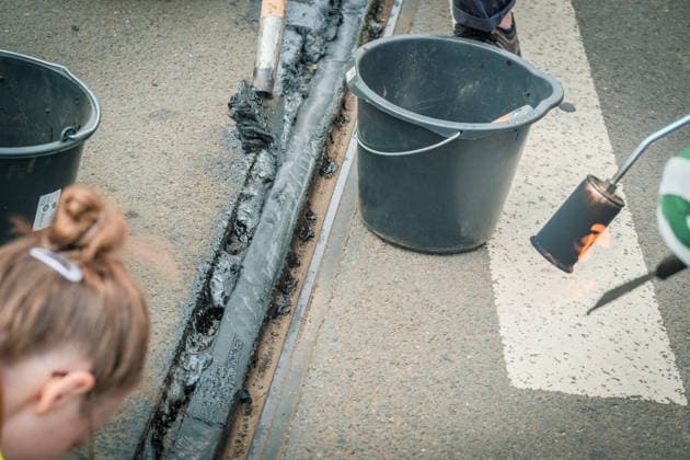 Freiwillige Helfer reinigen gemeinsam mit Mitarbeitenden der Leipziger Verkehrsbetriebe (LVB) Straßenbahngleise an der Leibnizstraße in Leipzig (Sachsen) von geschmolzenem Bitumen. Die Arbeiten sind Teil eines dritten Subbotniks zur Beseitigung der Hitzeschäden am Straßenbahnnetz. Aufnahme vom 4. Juli 2026. Hilfsaktion Leipzig *** Volunteers are working alongside employees of the Leipzig Public Transportation Authority (LVB) to clean melted bitumen from the tram tracks on Leibnizstraße in Leipzig, Saxony. The work is part of a third subbotnik aimed at repairing heat damage to the tram network. Photo taken on July 4, 2026. VolunteerLeipzig Relief Effort