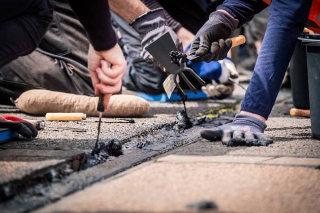 Freiwillige Helfer reinigen gemeinsam mit Mitarbeitenden der Leipziger Verkehrsbetriebe (LVB) Straßenbahngleise an der Leibnizstraße in Leipzig (Sachsen) von geschmolzenem Bitumen. Die Arbeiten sind Teil eines dritten Subbotniks zur Beseitigung der Hitzeschäden am Straßenbahnnetz. Aufnahme vom 4. Juli 2026. Hilfsaktion Leipzig *** Volunteers are working alongside employees of the Leipzig Public Transportation Authority (LVB) to clean melted bitumen from the tram tracks on Leibnizstraße in Leipzig, Saxony. The work is part of a third subbotnik aimed at repairing heat damage to the tram network. Photo taken on July 4, 2026. VolunteerLeipzig Relief Effort